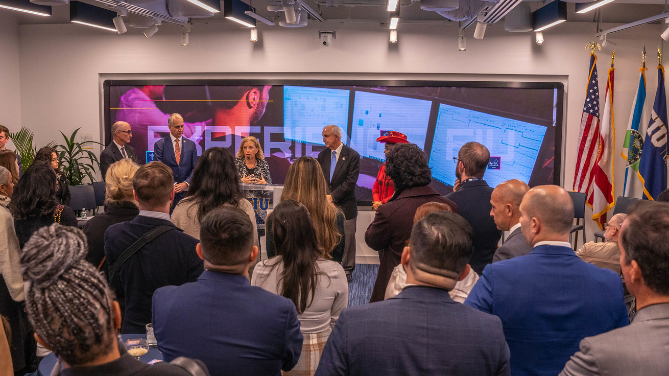 a crowd of people surrounds the FIU in DC 18 foot interactive screen